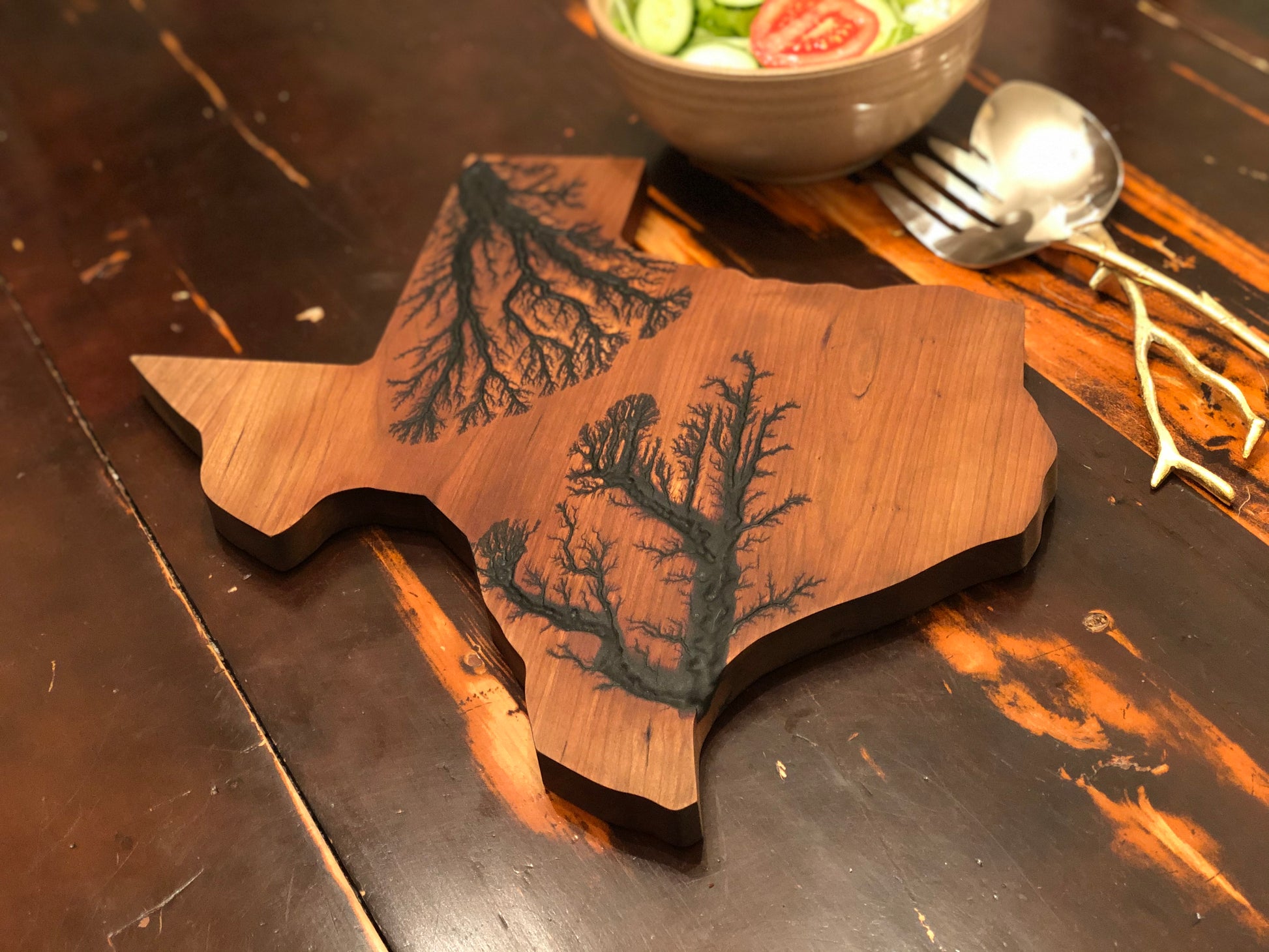 texas charcuterie board on a table with a salad in the background.