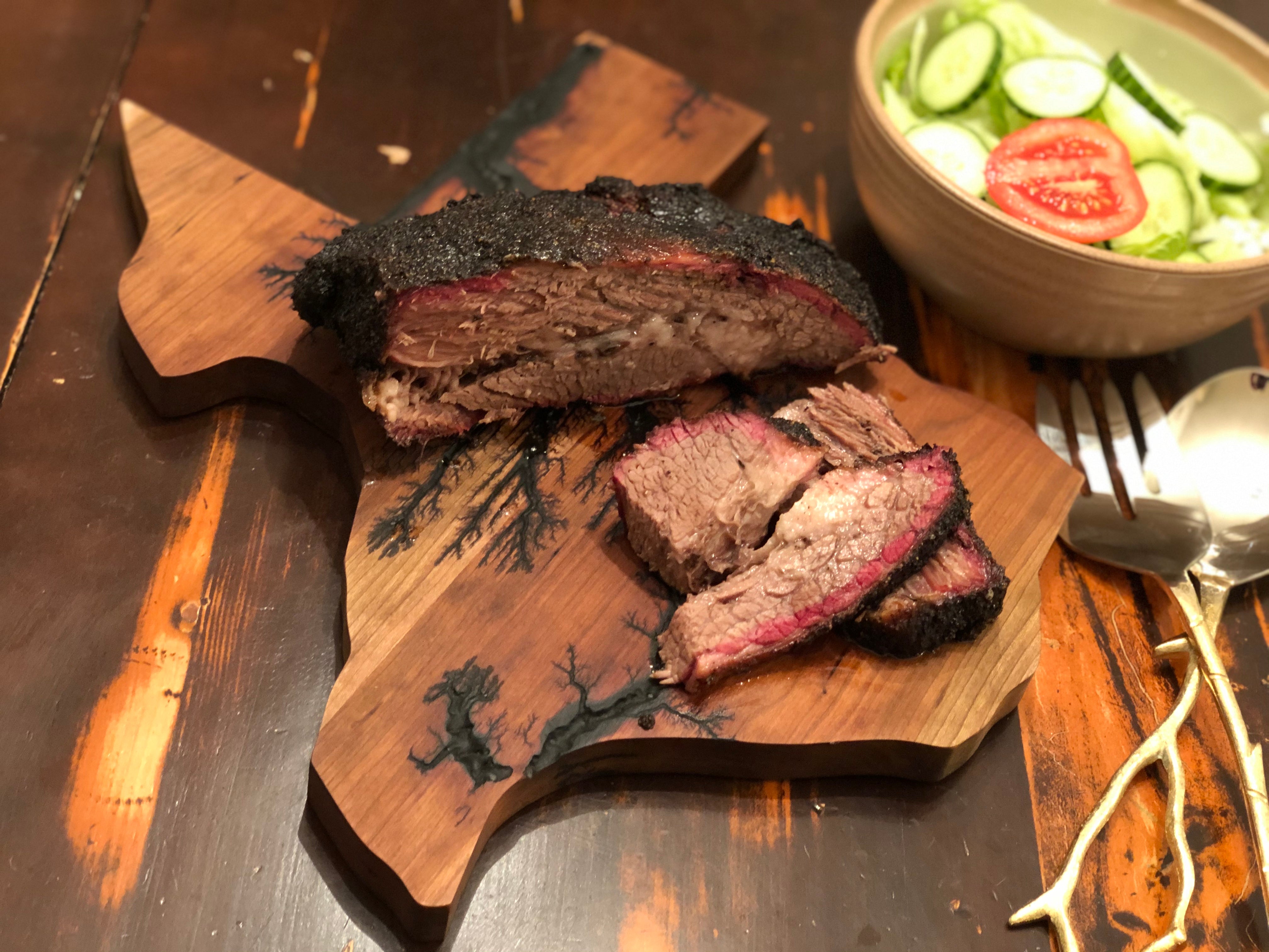 Texas cheese board with ribs on top and a salad in the corner.